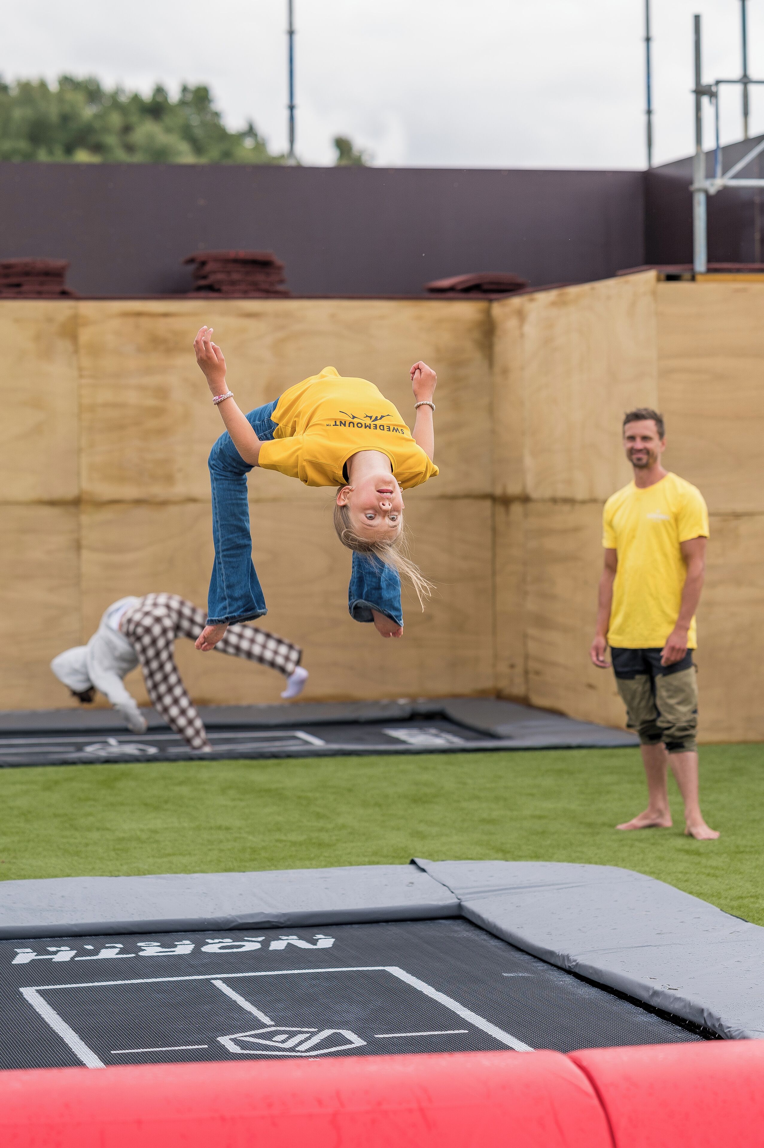 A trampoline with a safety net and a person performing a flip.