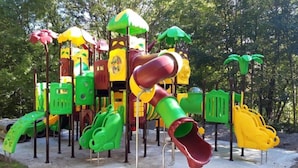 Un parque infantil con diversas estructuras de juego, incluyendo toboganes y zonas de escalada.