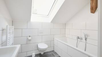 Chuveiro, toalhas de banho, sabonete, papel higiênico