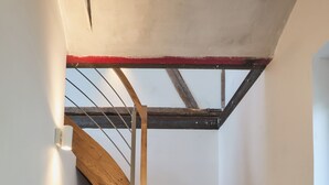 A wooden staircase with a metal handrail and a red accent at the top.