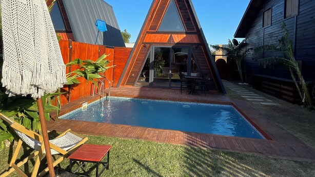 A modern house with a triangular roof, a swimming pool, and a fenced backyard. - Olive Garden  (Konyaalti)