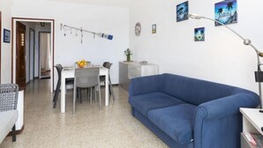 Un espacio habitable compacto con comedor, sofá y kitchenette.