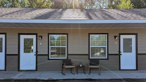 A two-story building with a flat roof, numbered doors, and windows with blinds. - The Greenland Motel - Room No.2 (Munising)