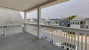 Een overdekt balkon met uitzicht op een woonwijk.