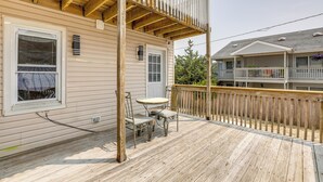 A wooden deck with a table and chairs, a covered porch area, and a view of neighboring buildings. - Seaside Heights Apartment Near Beach + Boardwalk! (Seaside Heights)