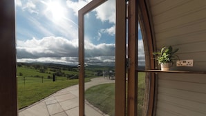 Una habitación con un ventanal grande que ofrece vistas a un paisaje verde y un cielo nublado.