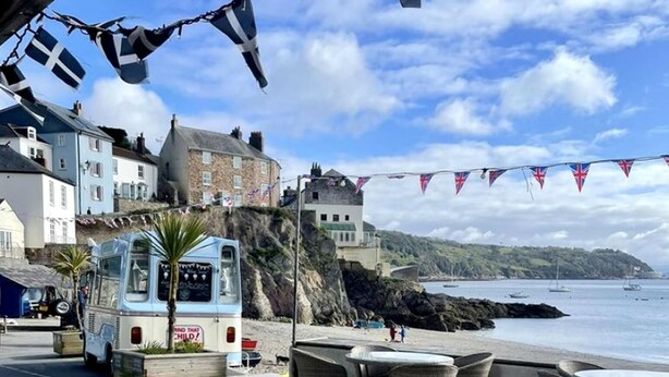 A coastal area with a beach, a parked bus, and buildings in the background. - Boutique Luxury Bell Tent Near Torpoint (Torpoint)