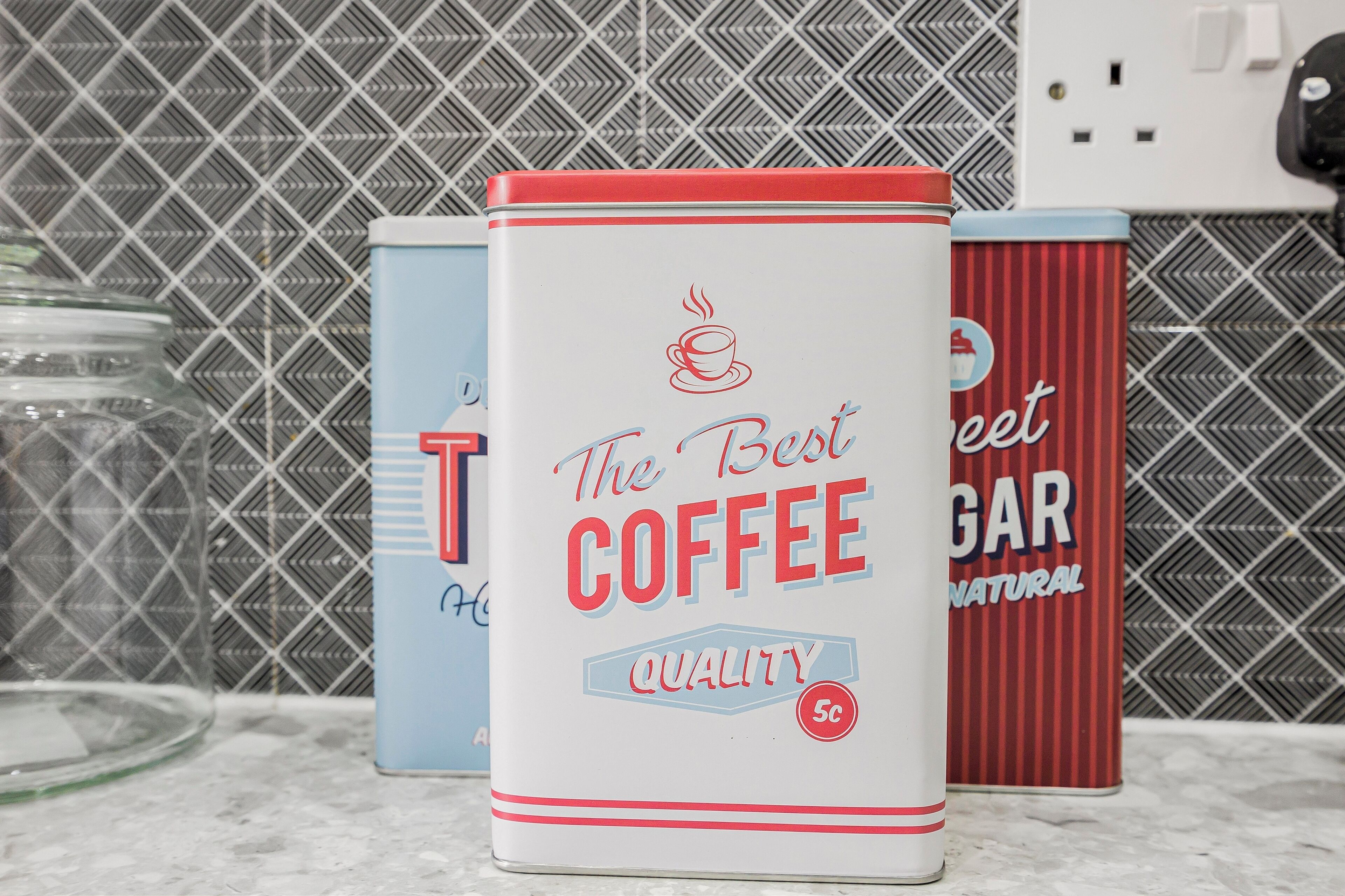 Three coffee tins on a countertop.