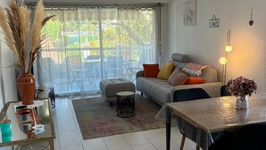 A modern living room with a sofa, coffee table, and dining table.