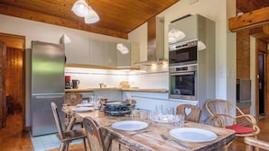A wooden dining table set with plates, glasses, and cutlery. - Rustic chalet with garden in Chamonix (Chamonix-Mont-Blanc)