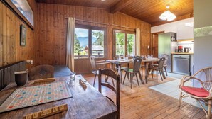 A wooden interior with a dining area, a kitchen, and large windows. - Rustic chalet with garden in Chamonix (Chamonix-Mont-Blanc)