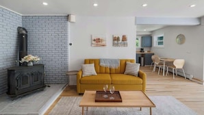 A modern living room with a sofa, coffee table, and artwork on the wall. - Renovated Condo in Luxury Neighborhood (Stowe)