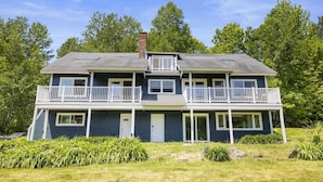 A two-story house with a balcony on the first floor and a chimney. - Renovated Condo in Luxury Neighborhood (Stowe)
