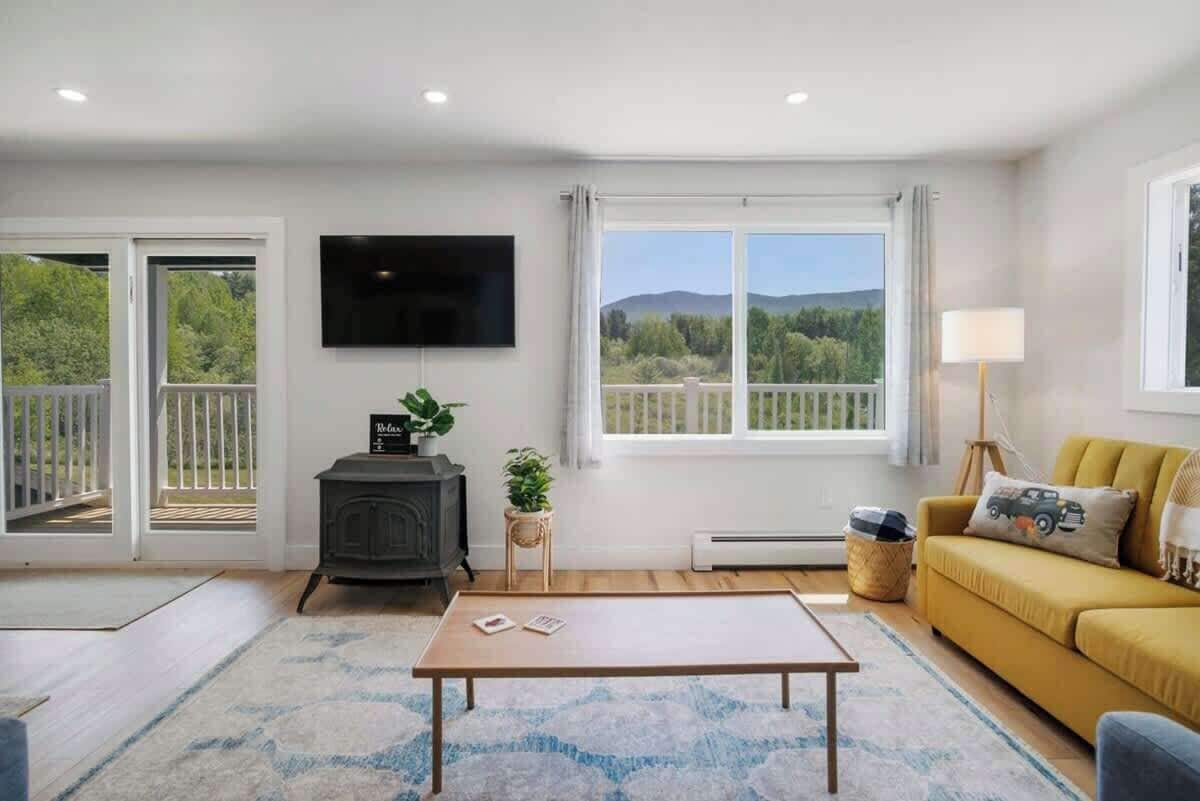 A living room with a sofa, a coffee table, a TV, and a fireplace.