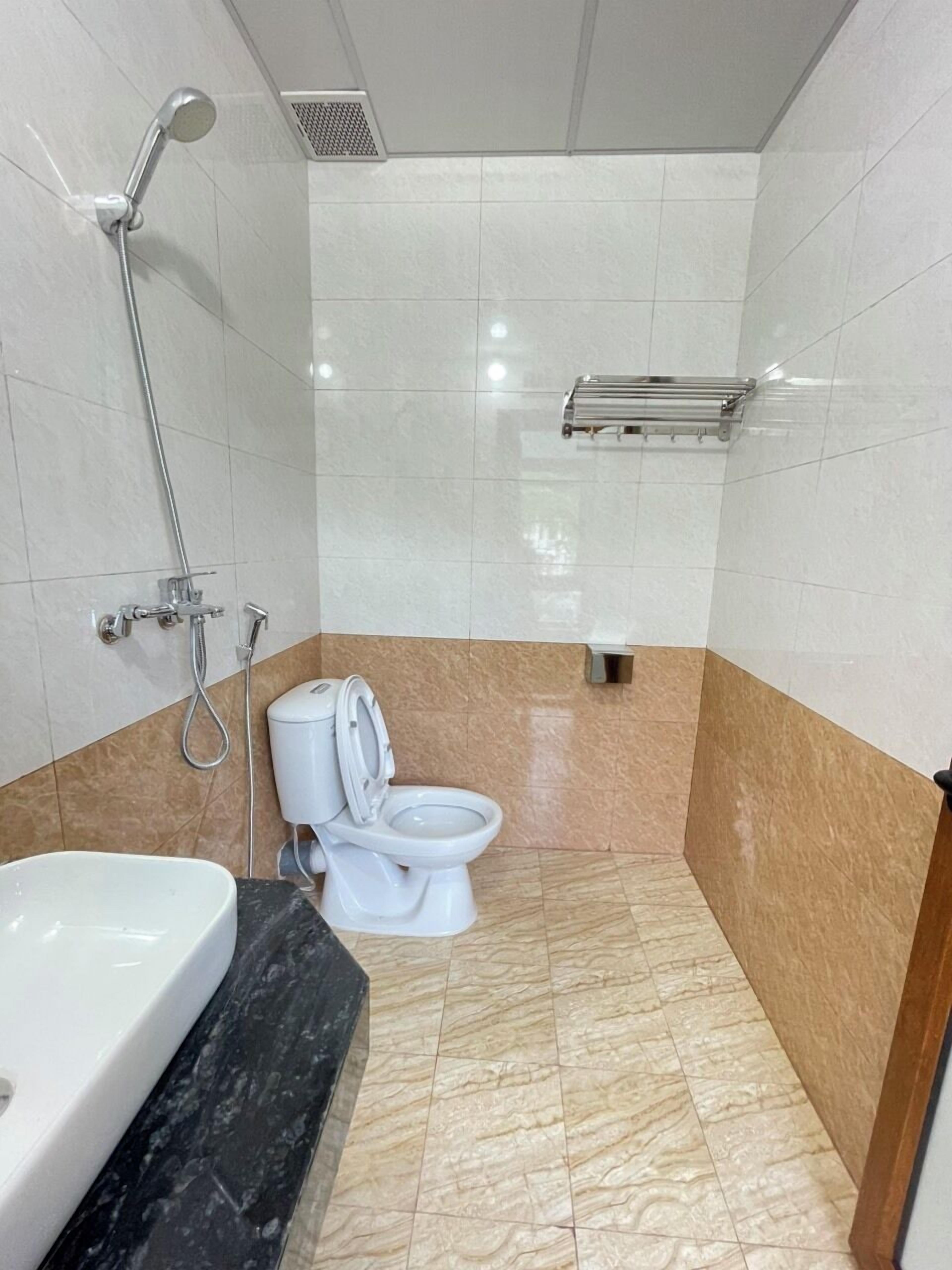 Een badkamer met toilet, douche en wastafel.