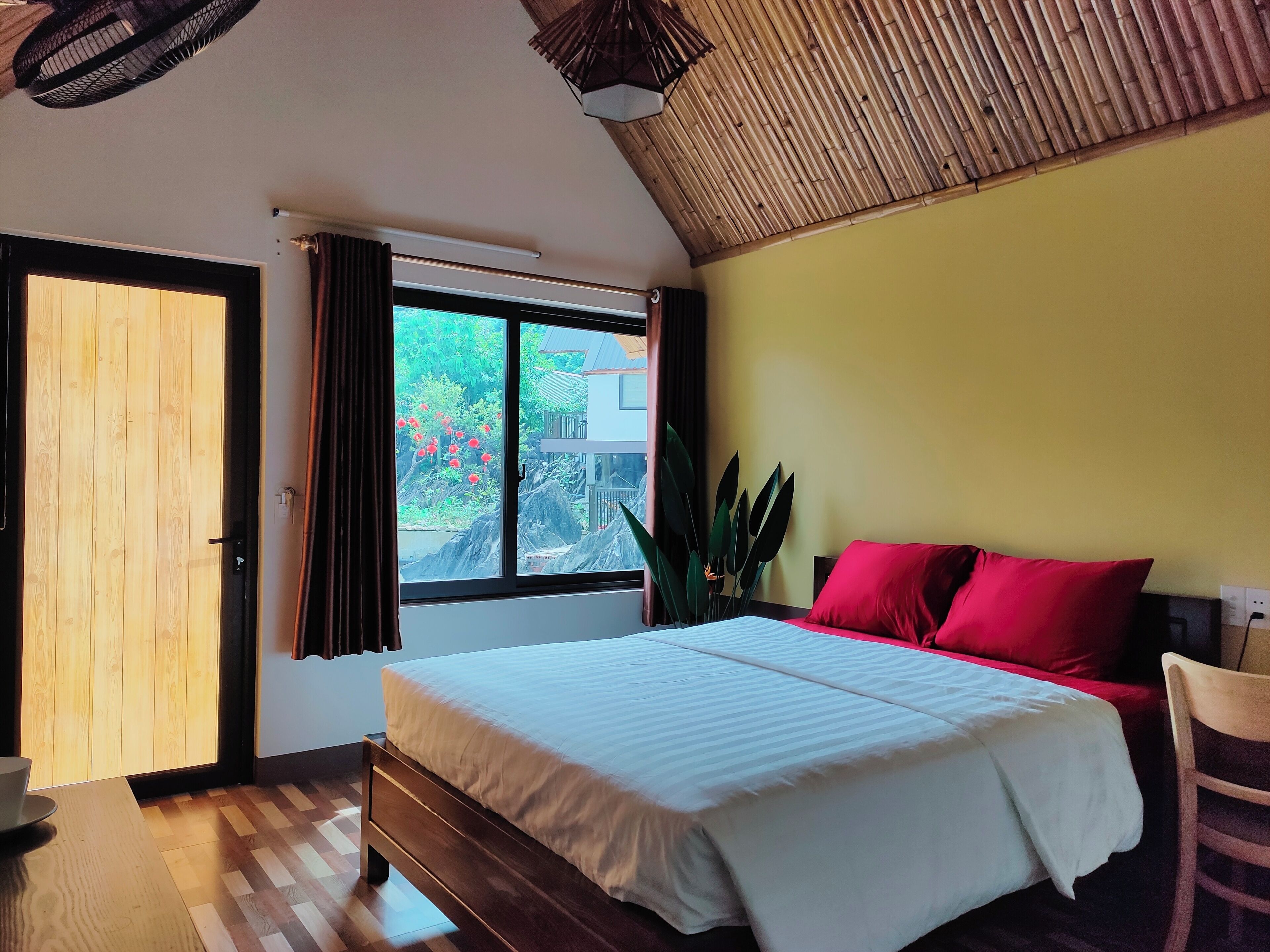 Une chambre à coucher avec un lit, une fenêtre, une chaise et une table.