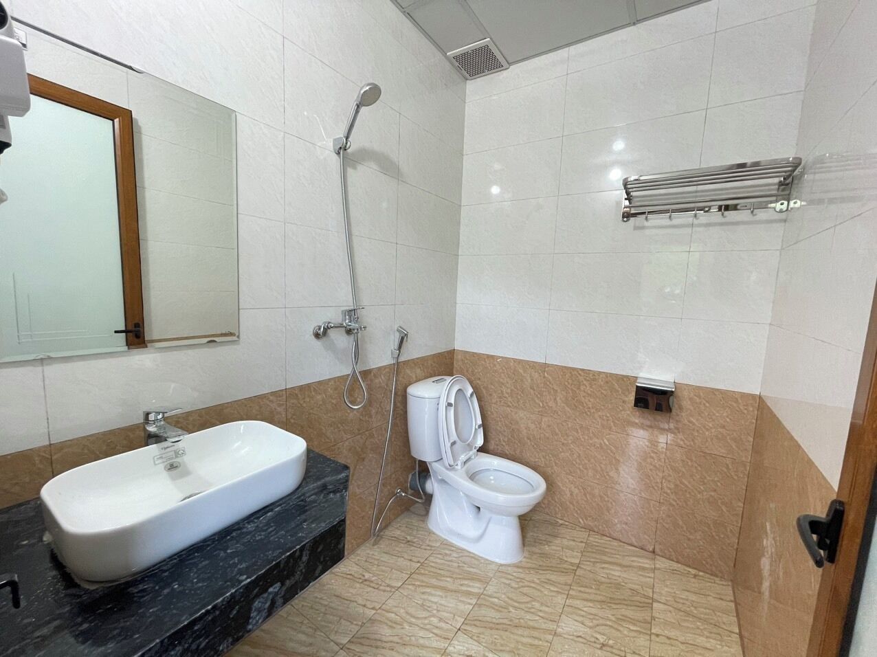 Un baño con lavamanos, inodoro y ducha.