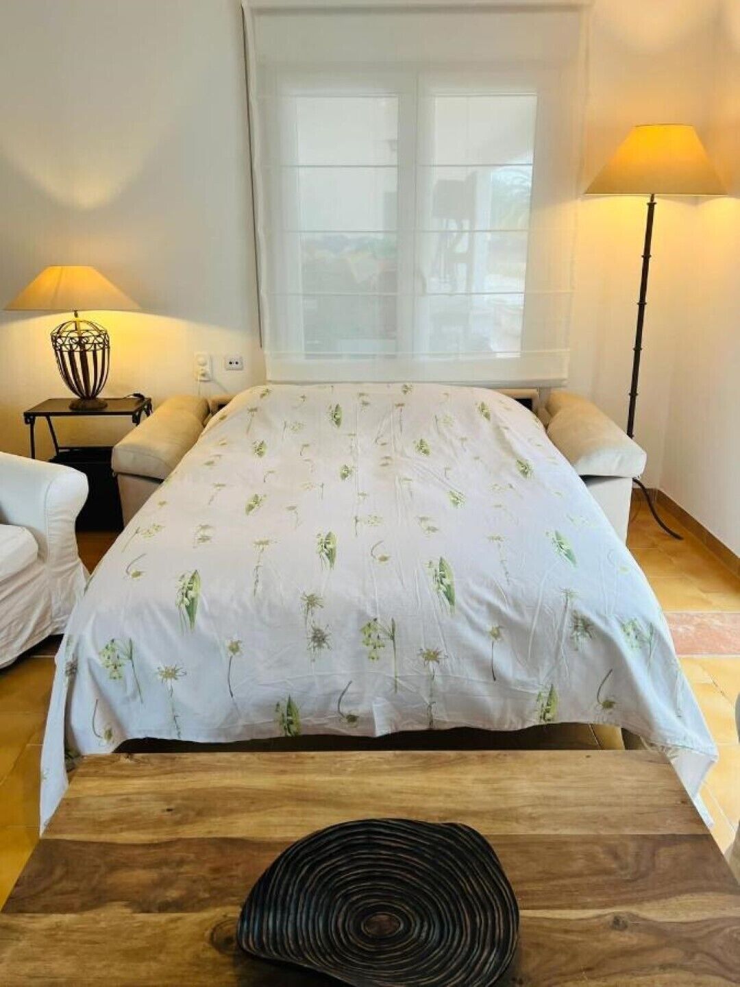 Et soveværelse med en seng, to sengeborde, en lampe og et vindue.