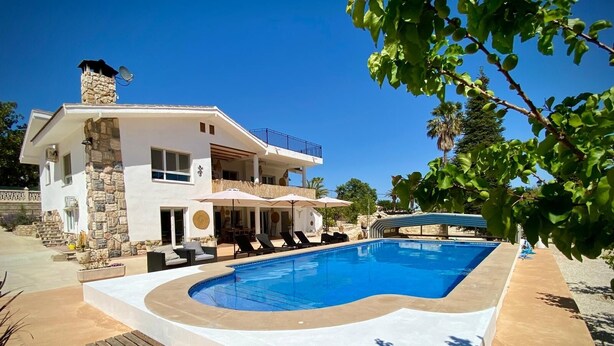 A modern two-story house with a swimming pool, outdoor seating, and a stone chimney. - B&B Casa Mil Sueños (Ontinyent)