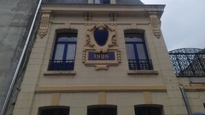 A building with a prominent number '1926' on its facade, featuring classical architectural elements like columns and decorative moldings. - L'étoile D'arras (Arras)