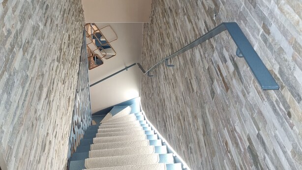 A staircase with a patterned wall on either side and a decorative ceiling design. - L'étoile D'arras (Arras)