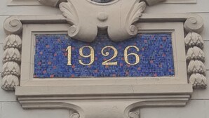 A building facade with a decorative shield-shaped window and a mosaic plaque with the number "1926". - L'étoile D'arras (Arras)
