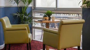 Two yellow chairs with a small round table and a potted plant between them. - Tor Park Hotel (Torquay)