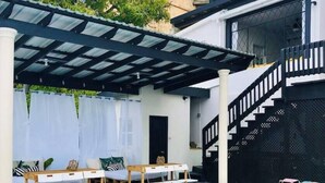 A pool area with a covered seating area, a staircase, and a door leading to an upper level. - Micro-Studio APT 5B, Oceanview + Pool, Near Beach | @ Paradise Point Barbados (Maxwell)