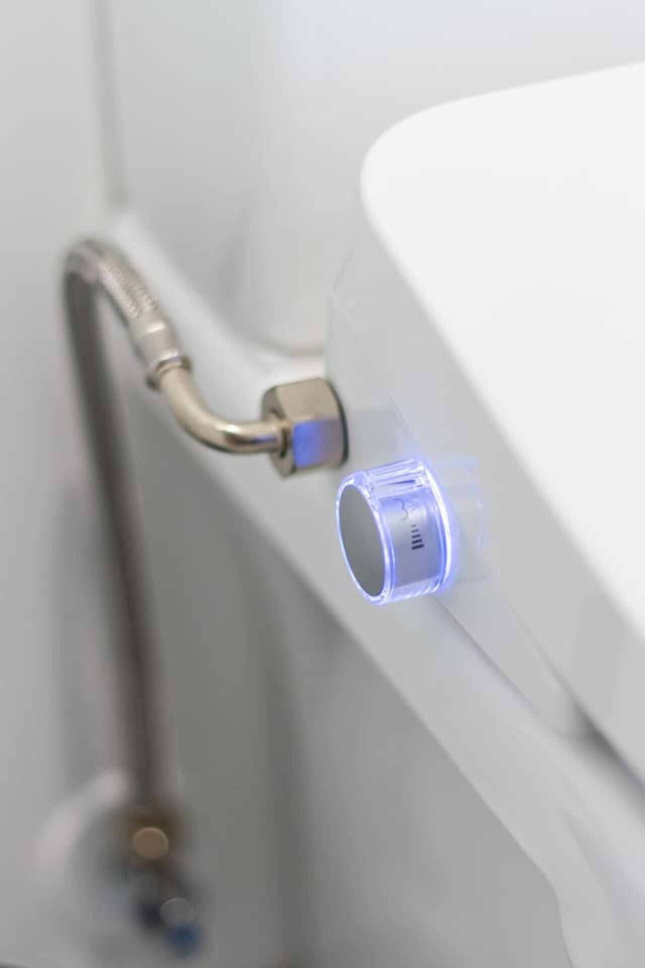 A bathroom with a white sink and a visible pipe.