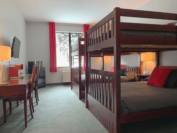 A bunk bed room with a desk, chair, and a TV. - Auberge Val Saint-Côme (Saint Come)