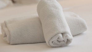 A neatly made bed with white linens and pillows. - Napoli Forever (Naples)