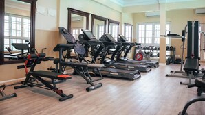 A gym with treadmills, weight machines, and dumbbells. - Zimansky Hotel  (Accra)