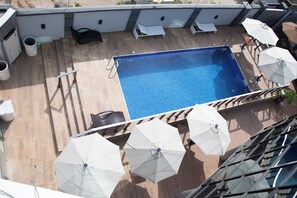 Relax by the pool surrounded by comfortable lounge chairs and shaded by umbrellas.