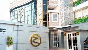 A modern building with a reception area, large glass windows, and a logo on the facade. - Zimansky Hotel  (Accra)