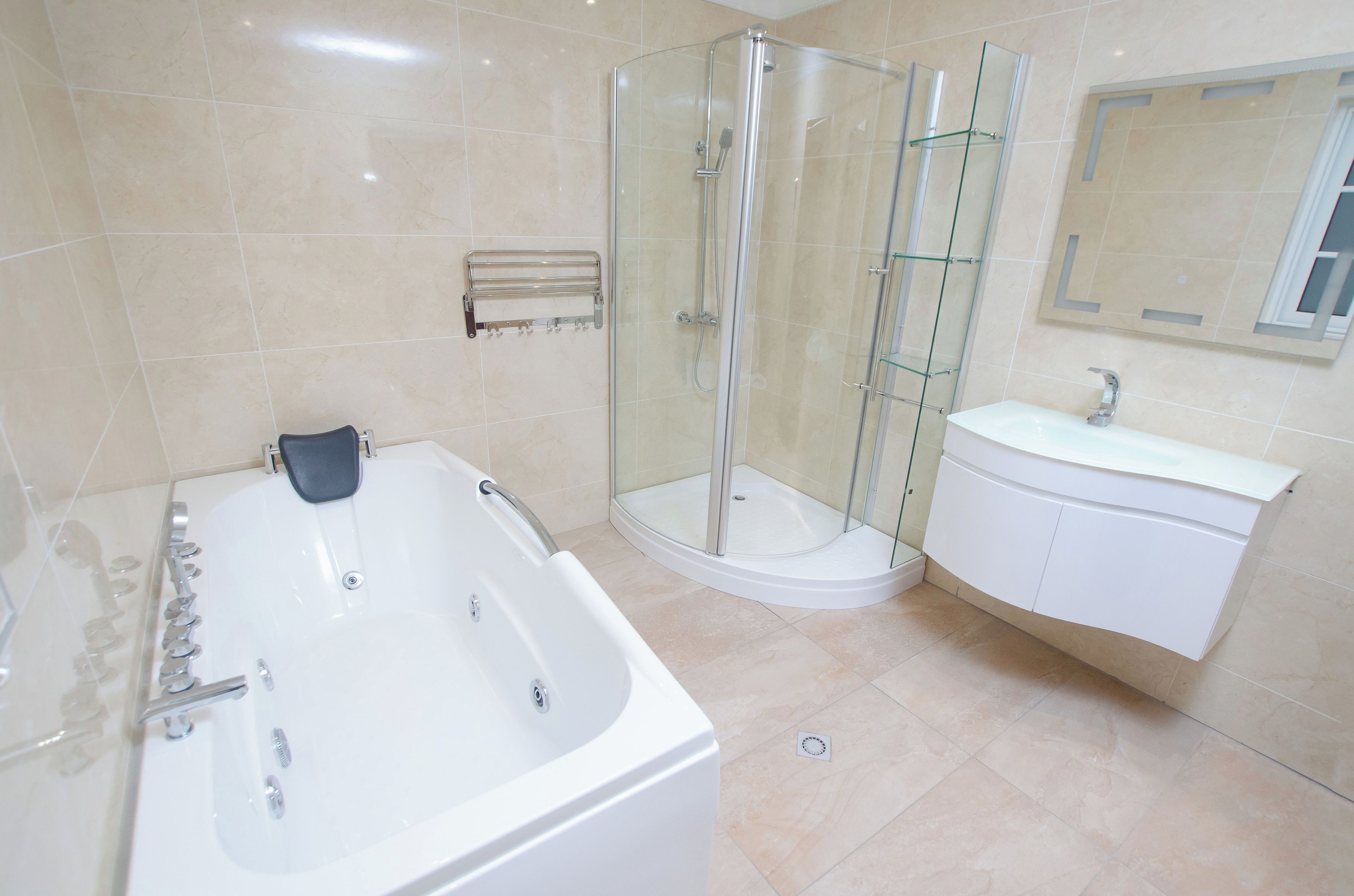 A modern bathroom with a glass-enclosed shower, a standalone bathtub, and a white vanity with a mirror.