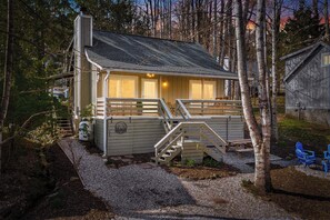 A cabin with a deck, a staircase, and a small outdoor seating area. - Maggie Valley Mtn Escape w/ Fire Pit & Deck (Maggie Valley)