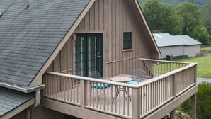 A wooden cabin with a balcony, a small window, and a door. - Country living in a private setting, The Loft at Springhouse Farm (Rockbridge County)
