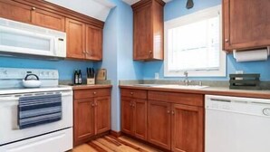 A kitchen with wooden cabinets, a white stove, and a window. - Country living in a private setting, The Loft at Springhouse Farm (Rockbridge County)