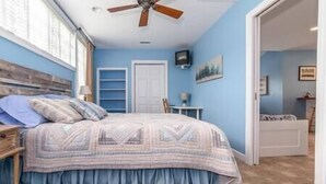 A bedroom with a bed, a ceiling fan, a TV, and a door leading to another room. - Country living in a private setting, The Loft at Springhouse Farm (Rockbridge County)