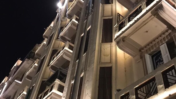 Un edificio a più piani con balconi e una scala centrale.
