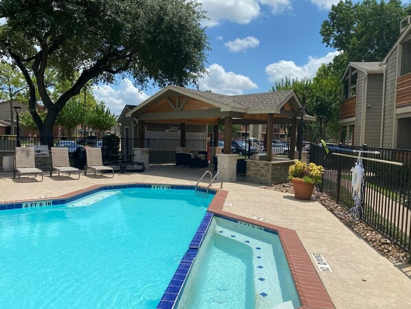 A rectangular pool with a 4 ft 6 in depth and 3 ft 6 in width, surrounded by a covered seating area with chairs and a table, and a potted plant.