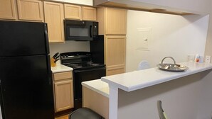 A compact kitchen with a black refrigerator, a microwave, a stove, and a sink. - Cozy 1BR Apt in Medical Center. Close to Downtown/ Zoo/ Medical Center  (Houston)