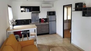 Un espacio habitable compacto con kitchenette, zona de comedor y área de descanso.