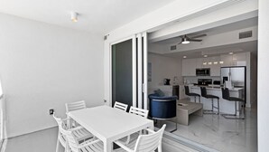 A modern kitchen with white cabinets, a microwave, and a refrigerator.