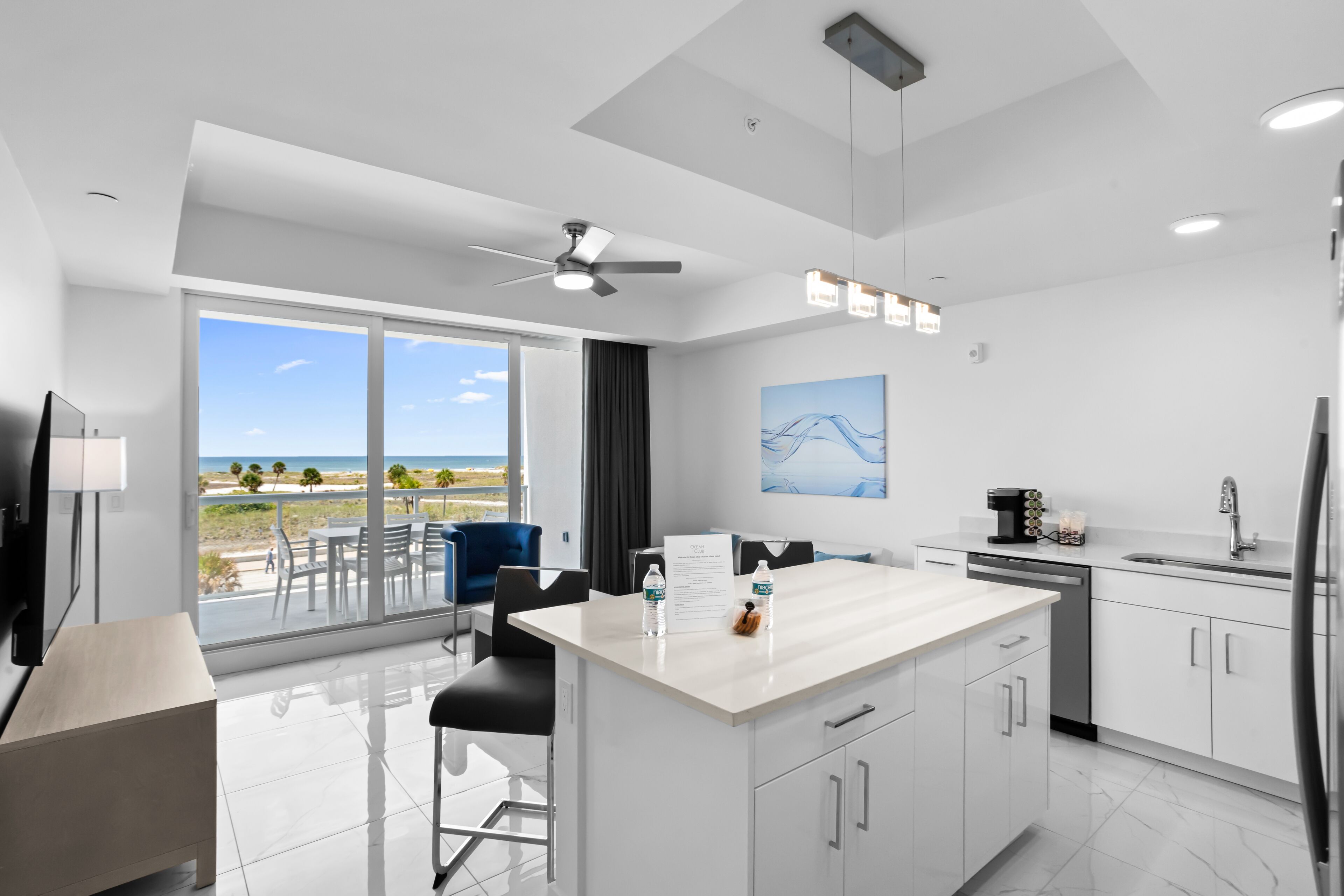 Una cocina moderna con una isla grande, un comedor con vistas y un balcón con vistas.