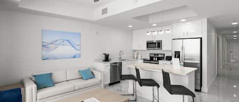Una cocina moderna con armarios blancos, microondas y refrigerador.