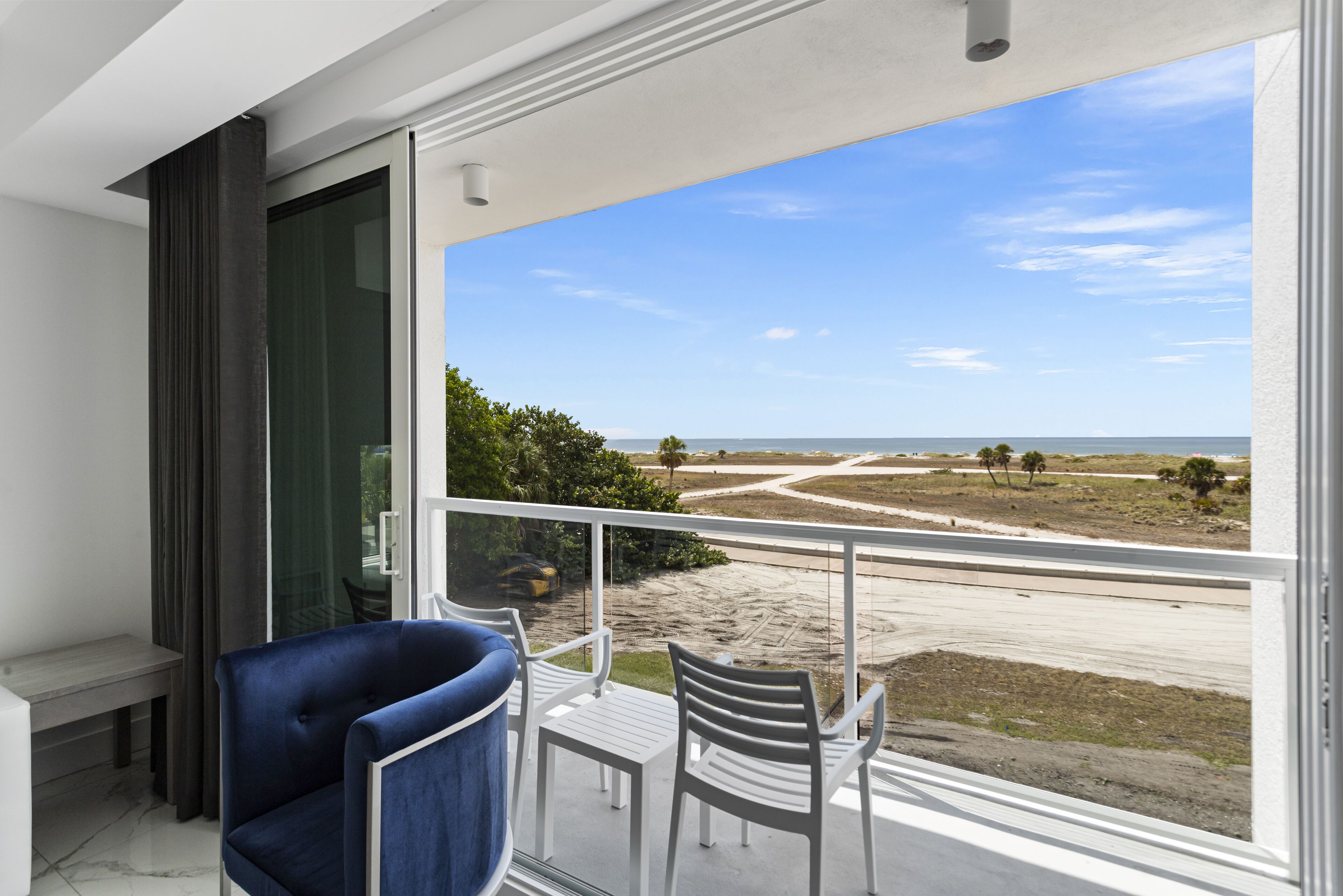 A balcony with a view of a beach and road.