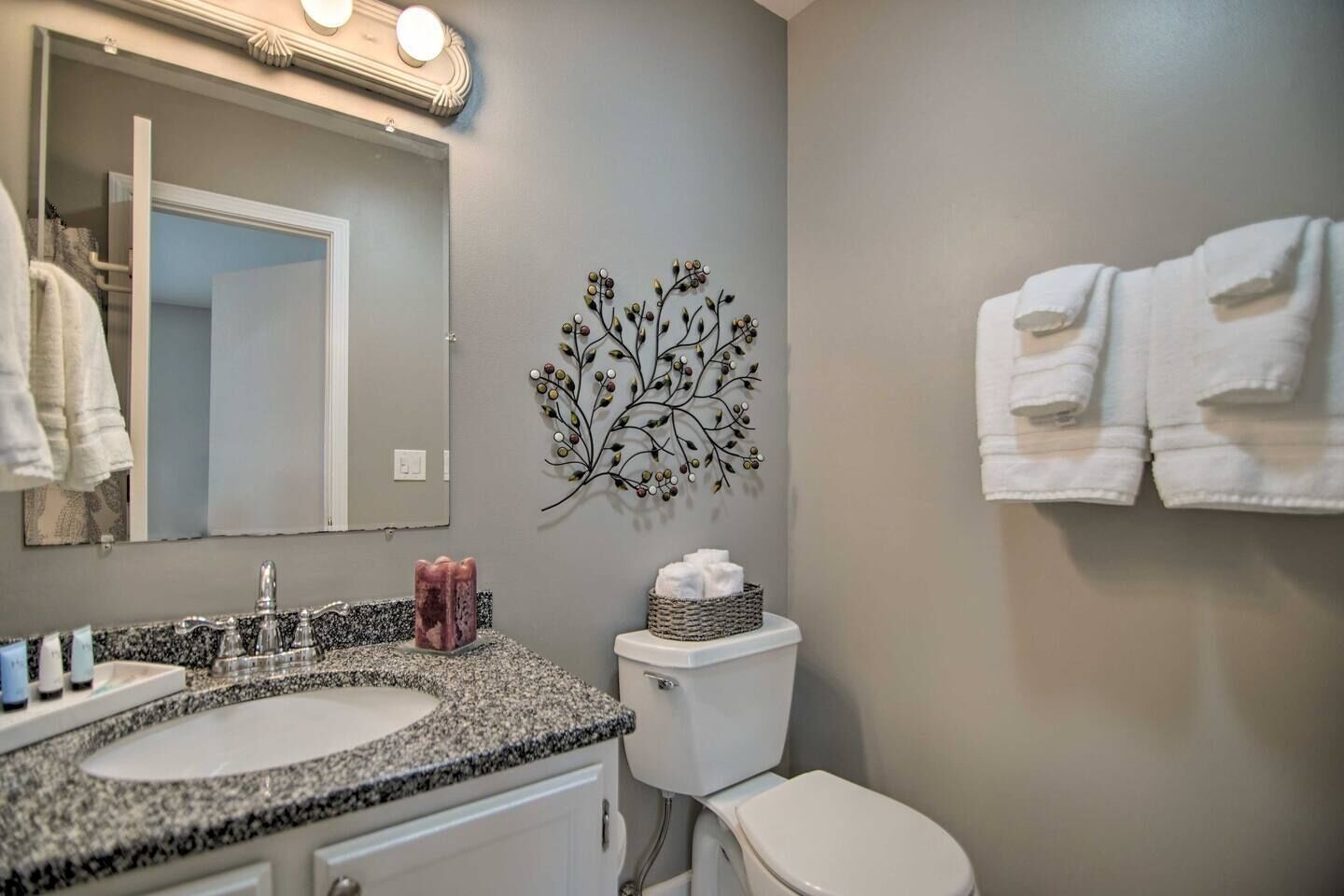 A bathroom with two sinks, a toilet, and a wall-mounted decorative tree.