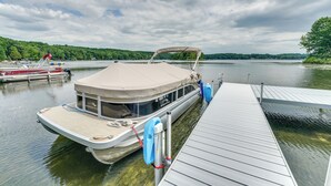 Un bateau était amarré à un quai, doté d’un espace de repos abrité et d’un pont blanc.