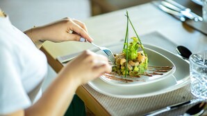 A person dining at a table with a plate of food, a fork, and a glass of water. - Villa Tacai - Six Bedroom Villa, Sleeps 12 (Sidi Youssef Ben Ali)